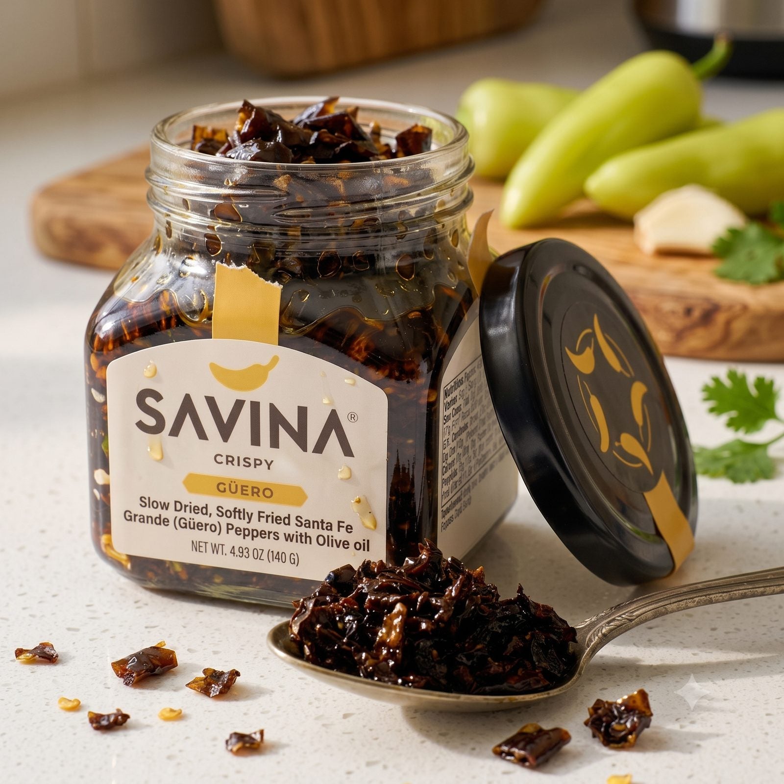 An open jar of Savina chile crisp with a spoonful of crisp and fresh chiles